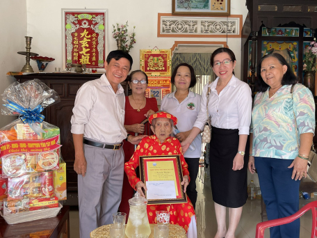 Đồng chí Võ Văn Sớm (bìa trái) thăm và tặng quà cho cụ Trương Thị Sẹo, thọ 102 tuổi
