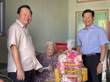 Đồng chí Nguyễn Mạnh Hùng (bìa phải) và đồng chí Trần Văn Khải (bìa trái) thăm và tặng quà cho mẹ Việt Nam Anh hùng Phạm Thị Bé