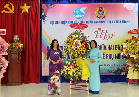 Đồng chí Kim Thị Minh (bên phải) tặng lẵng hoa chúc mừng cho Hội LHPN thị xã