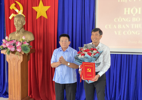 Đồng chí Võ Văn Dũng - Tỉnh ủy viên, Bí thư Thị ủy Trảng Bàng (đứng bên trái) tặng hoa và trao Quyết định cho đồng chí Nguyễn Minh Thuận