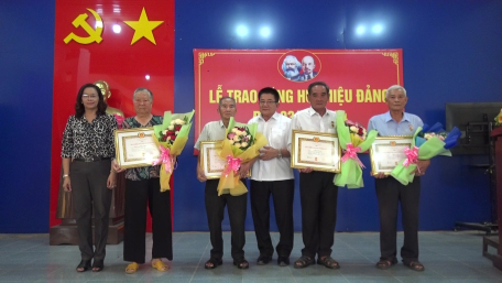 Đồng chí Võ Văn Dũng – Bí thư Thị ủy Trảng Bàng (thứ ba, từ phải qua) tặng hoa, trao Huy hiệu Đảng cho các đảng viên