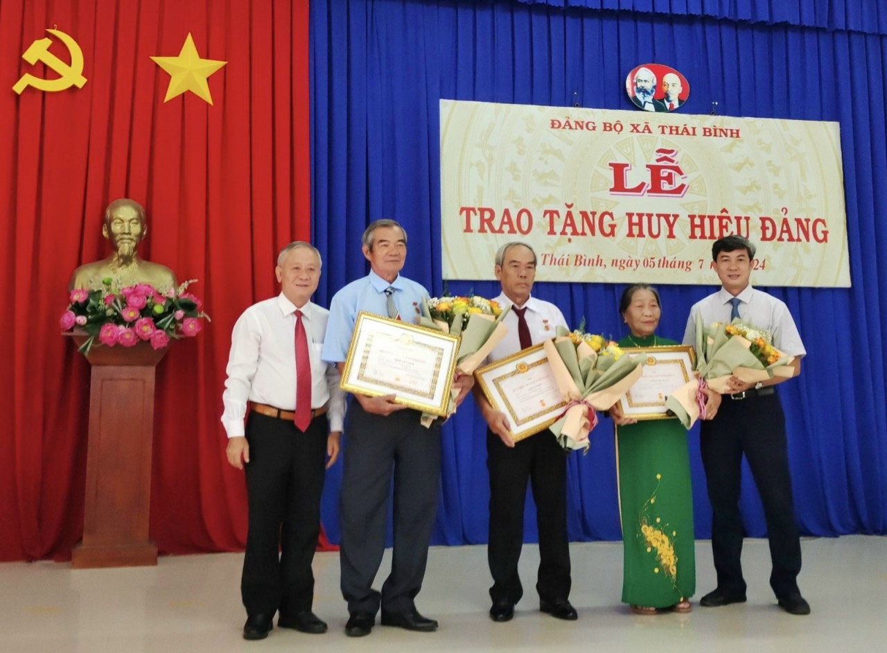 Bí thư Huyện uỷ Trương Văn Hoàn trao Huy hiệu Đảng, tặng hoa chúc mừng các đảng viên